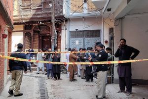 Politiet i Peshawar siger, at de to bevæbnede mænd kæmpede sig vej frem til moské og der udløste to bomber.
