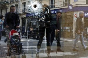 Et vindue ind til en café vidner om dramatikken, da en knivbevæbnet mand fredag fik amok i Paris. Politiet skød og dræbte manden tæt på det sted, hvor billedet er taget. Foto: Thibault Camus/AP