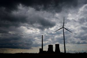 Kontrasten mellem fortid og fremtid stilles til skue i tyske Hohenhameln, hvor en vindmølle er rejst foran det kulfyrede kraftværk. Foto: AP/Julian Stratenschulte