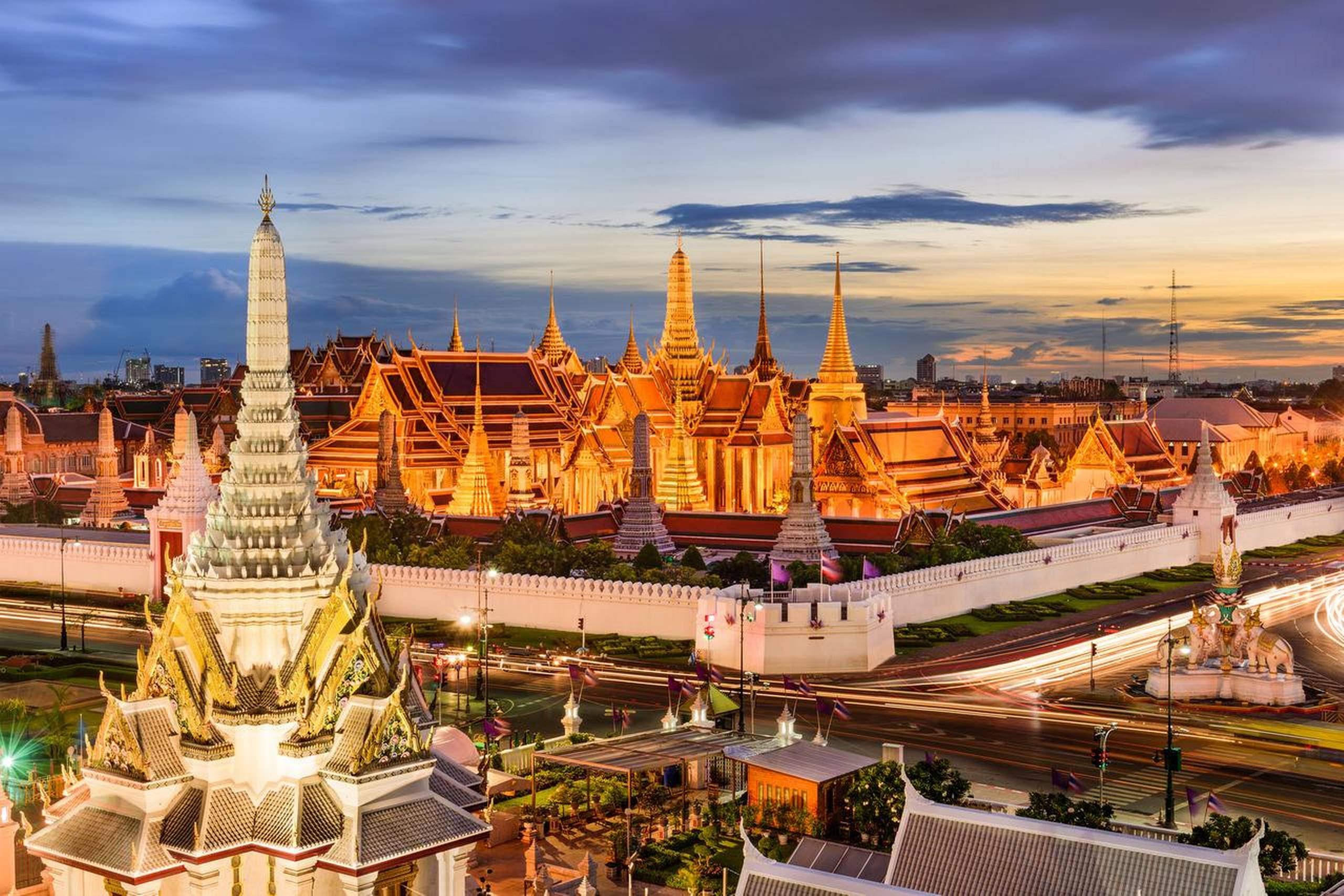 De ikoniske gyldne spir på smaragd-buddhaens tempel og Grand Palace lyser op i aftenmørket over Bangkok. Foto: Getty Images