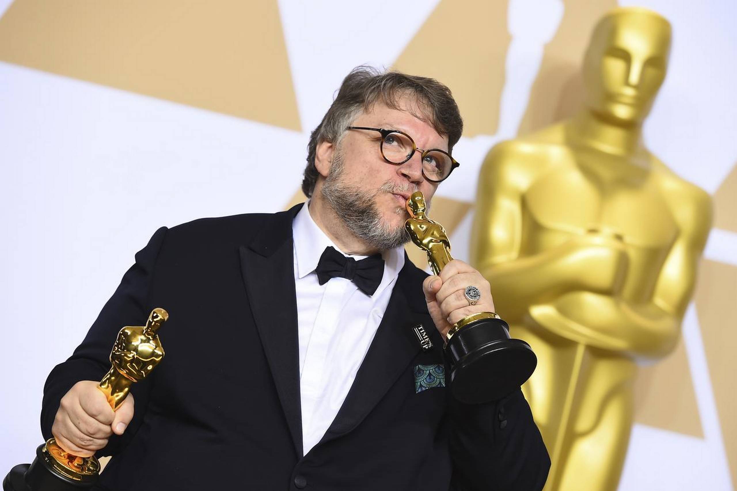 Den mexicanske instruktør Guillermo del Toro ses i presselokalet under den 90. udgave af ”the Oscars”. Han holder i højre og venstre hånd beviserne på, at han er årets vinder i kategorierne ”Bedste Film” og ”Bedste instruktør”. Han brugte Foto: Jordan Strauss/AP