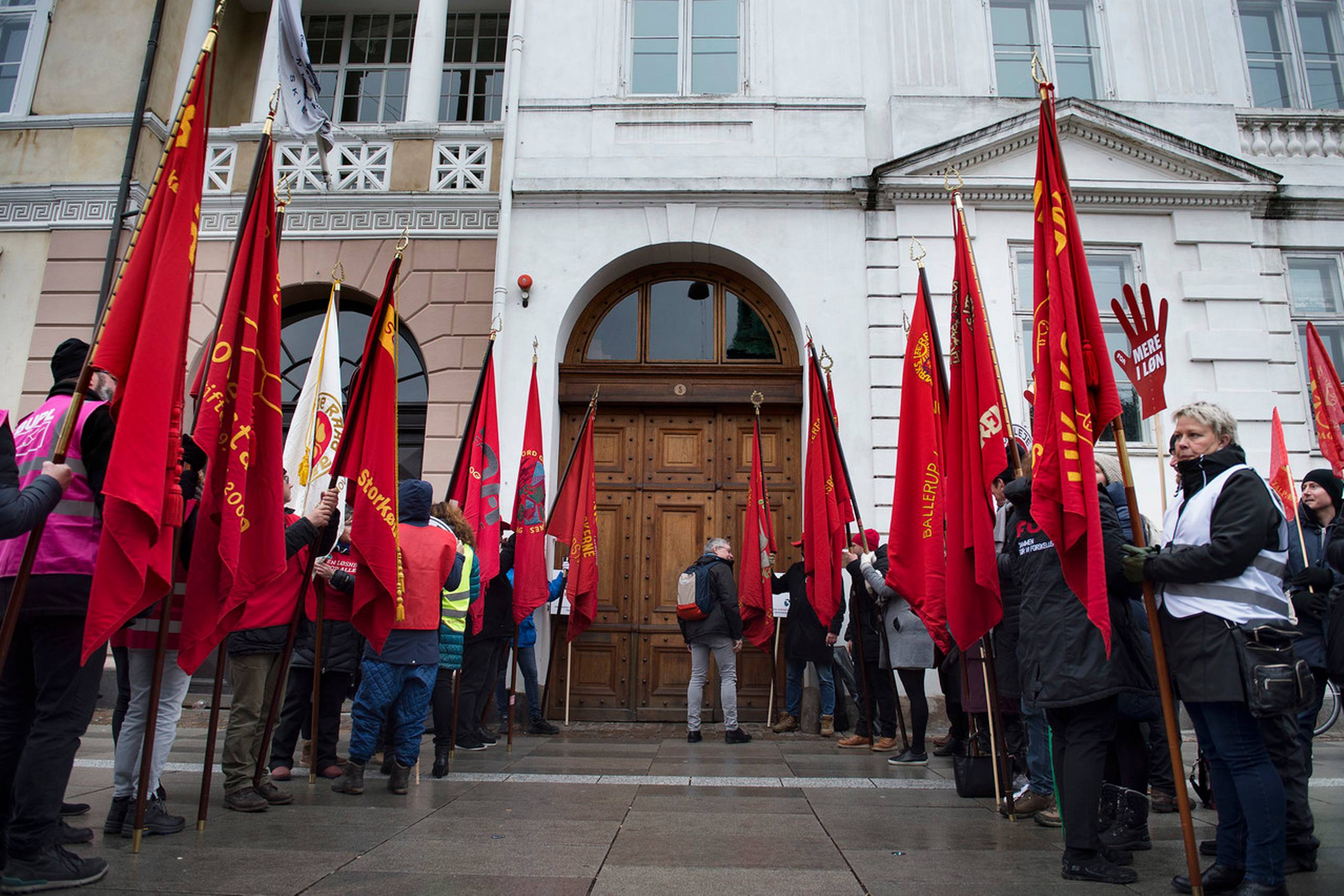 Røde faner og krav om mere i løn foran Forligsinstitutionen på Sankt Annæ Plads i København. De offentligt ansatte og arbejdsgiverne har mødtes hos forligsmanden siden slutningen af februar uden at nå et forlig. Foto: Liselotte Sabroe/Ritzau Scanpix