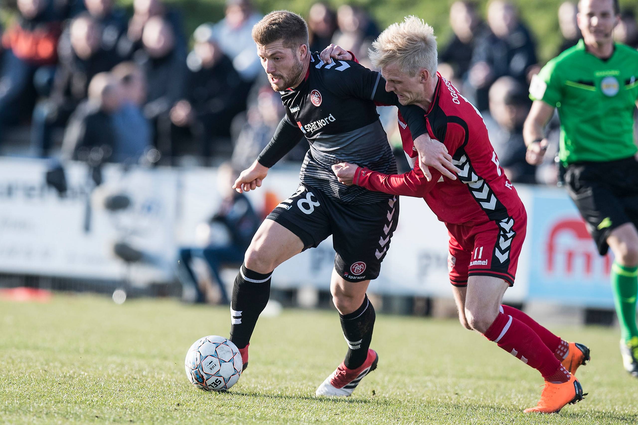 Det var ikke til at få øje på, hvem der spiller i 1. division, og hvem der er med i Superligaens mesterskabsspil, da FC Fredericia onsdag aften hjemme slog AaB ud af DBU Pokalens kvartfinale med en sejr på 3-1. Her  Yann Rolim (Aab - 28) mod Andreas Oggesen (Fredericia - 11). Foto: Claus Fisker