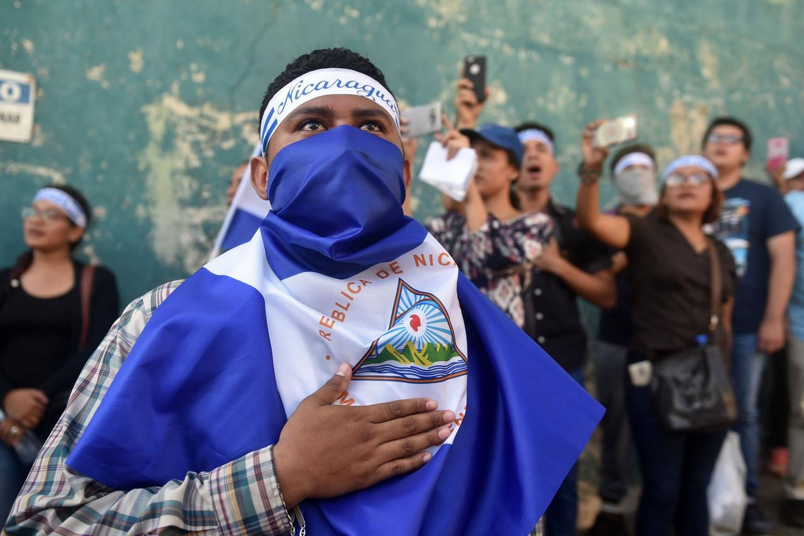 Det er de store følelser, der er på spil blandt demonstranterne i Nicaragua. Forleden stillede en gruppe op og sang foran politistationen i Managua i protest mod præsident Daniel Ortega. Foto: Rodrigo Arangua/AFP