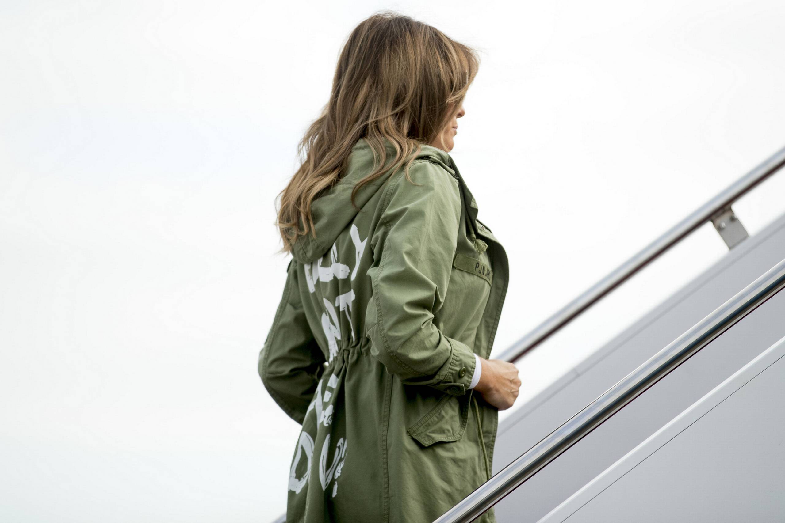 USA's førstedame Melania Trump går om bord på et fly i Andrews Air Force basen. Teksten bag på hendes jakkes kan lige anes. Foto: AP/Andrew Harnik