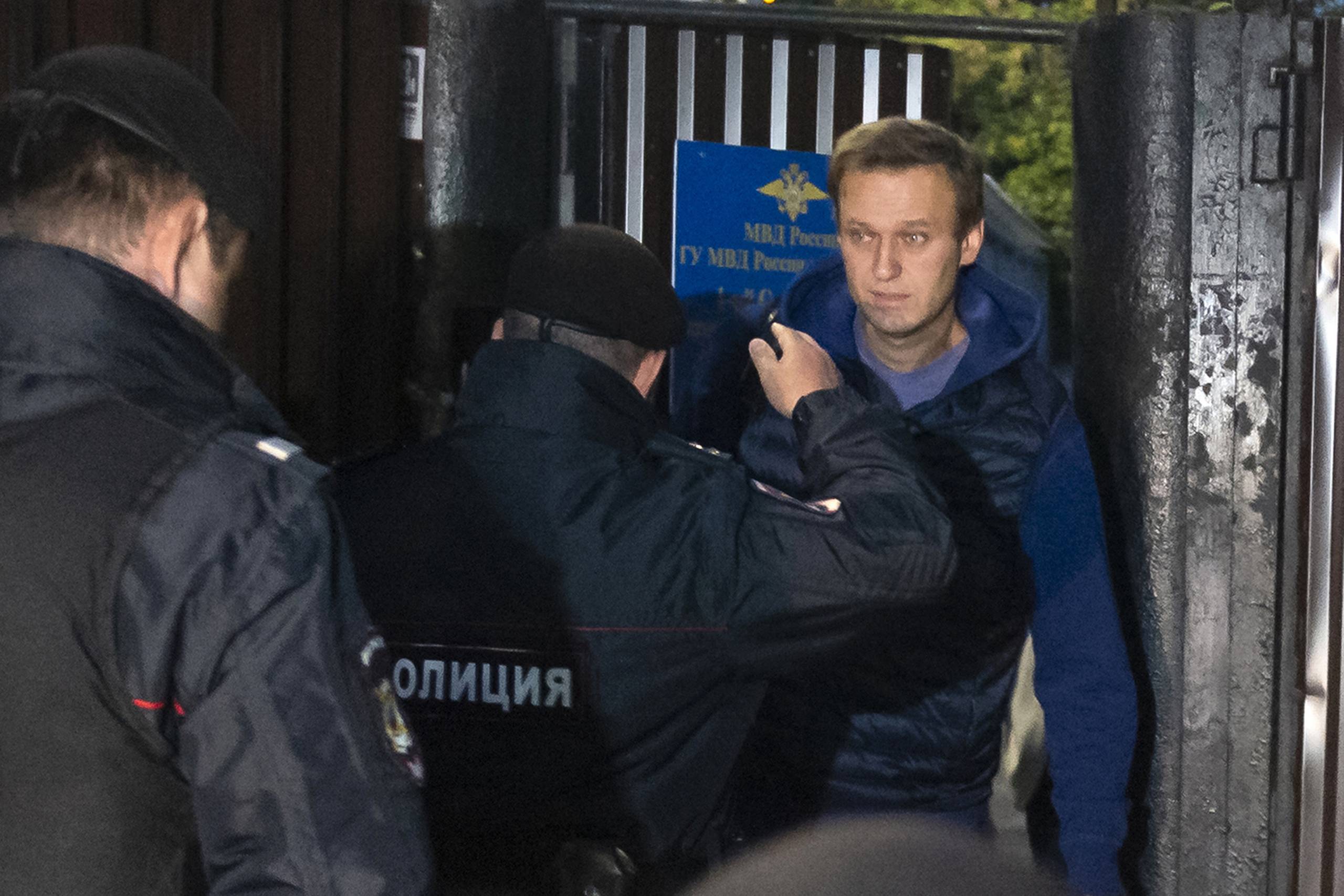 Politifolk kom op til Aleksej Navalnyj, i samme øjeblik som han trådte ud gennem døren fra detentionscenteret, hvor en del af hans tilhængere og pressefolk ventede på ham. Foto: Dmitry Serebryakov/AP