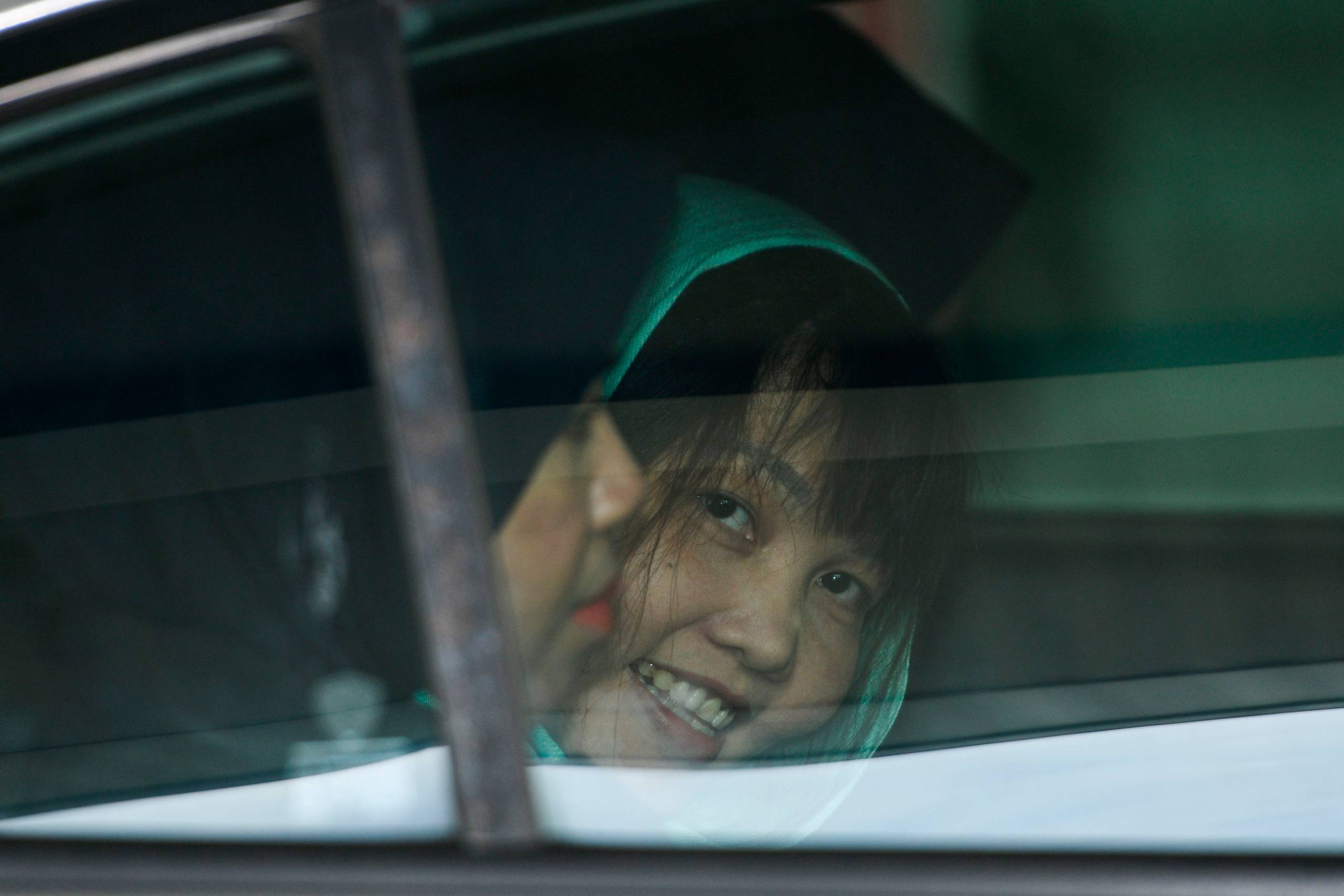 Doan Thi Huong smiler i bilen på vej væk fra retten i Shah Alam, Malaysia. Foto: Mohd Rasfan