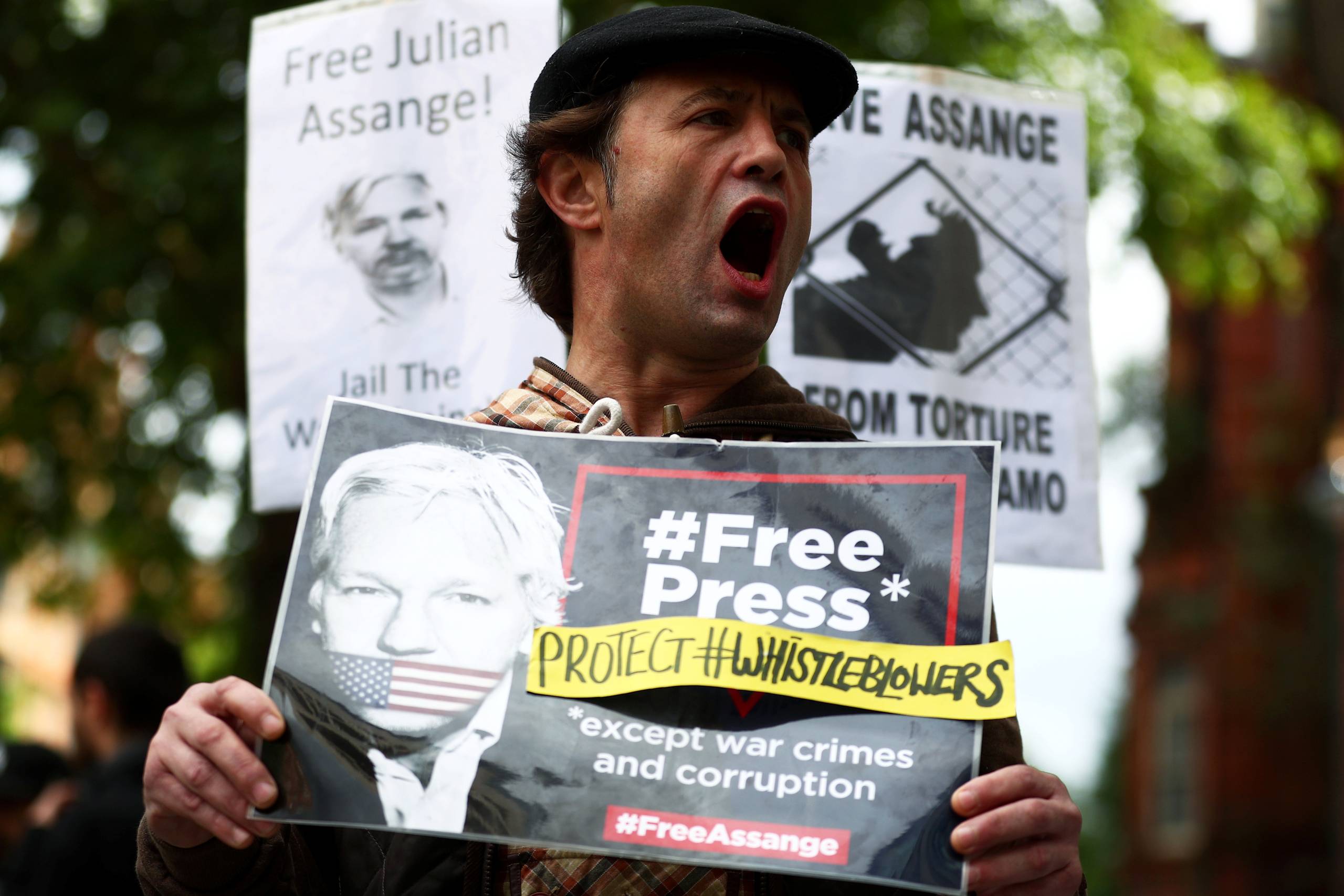 A demonstrator holding a placard protests outside of Westminster Magistrates Court, where a case hearing for U.S. extradition of Wikileaks founder Julian Assange is held, in London, Britain, June 14, 2019. Foto: Hannah Mckay/Reuters  