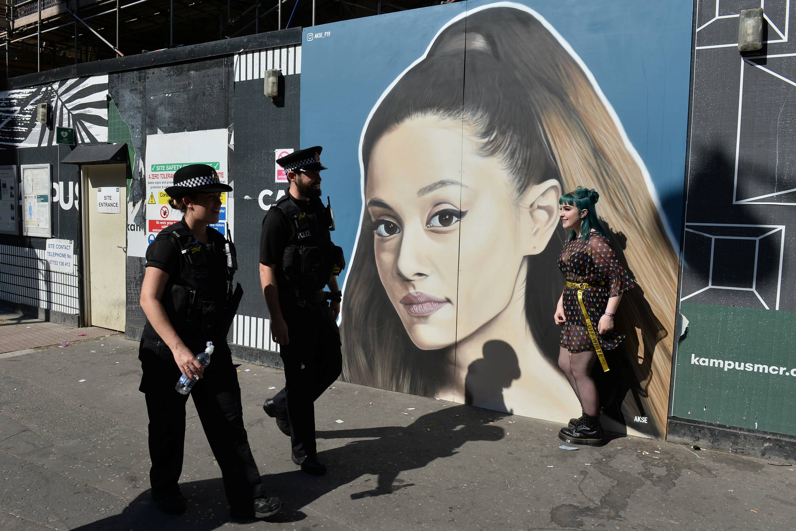 Politibetjente passerer en plakat af Ariana Grande under pridefestivalen i Manchester. Foto: Peter Powell/Reuters