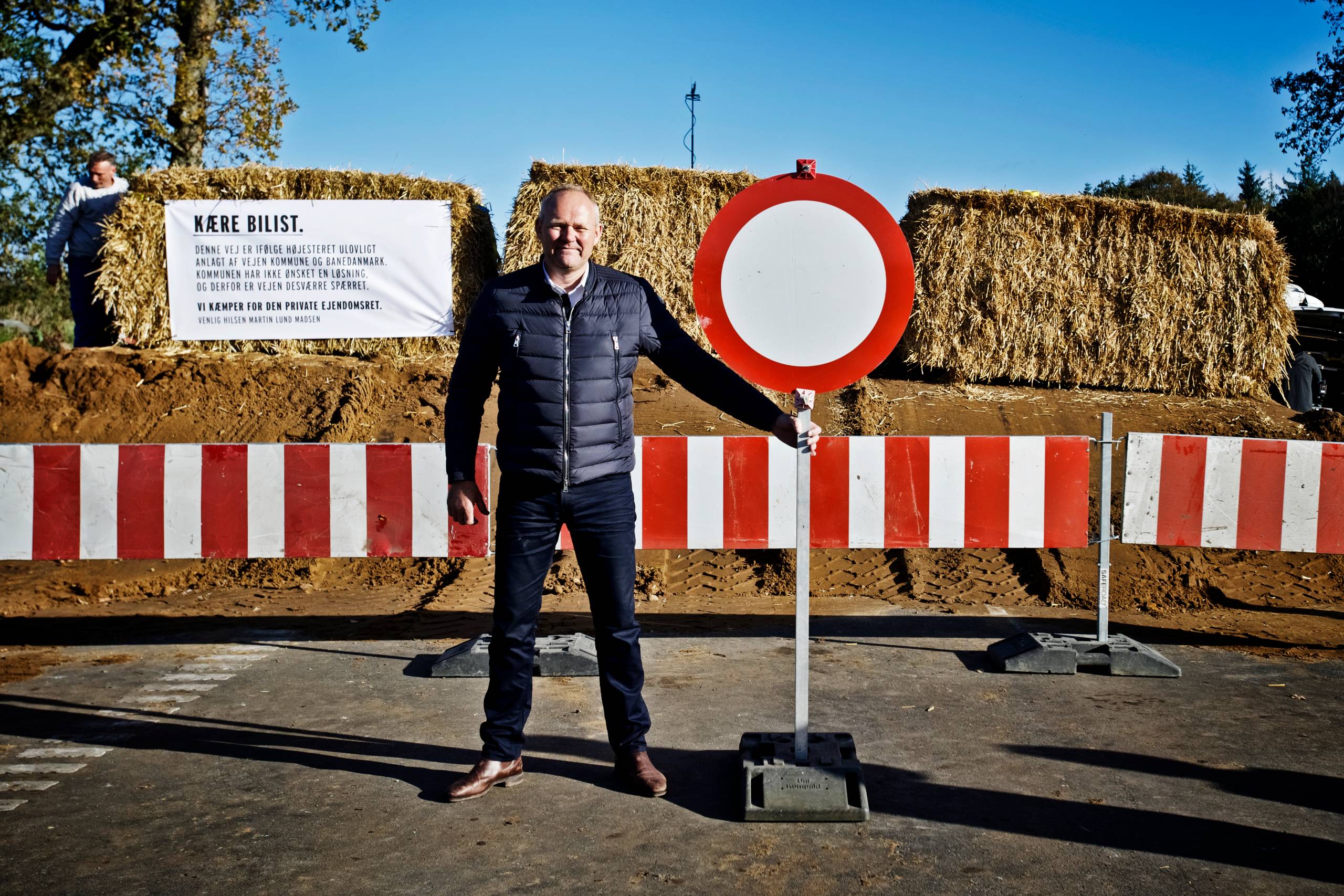 
    Landmand Martin Lund Madsen foran blokaden af Vejen ved Vejen. Mandag tog han sagen i egen hånd og blokerede offentlig vej gennem hans jord. Byretten i Esbjerg gav i 2015 Martin Lund Madsen ret i, at det var ulovligt at ekspropriere 21000 kvadratmeter af hans jord.
Den 10. september i år stadfæstede højesteret den dom og slog dermed fast, at det ikke var lovligt at etablere en ny kommunal vej på hans jord. Arkivfoto: Christer Holte
  