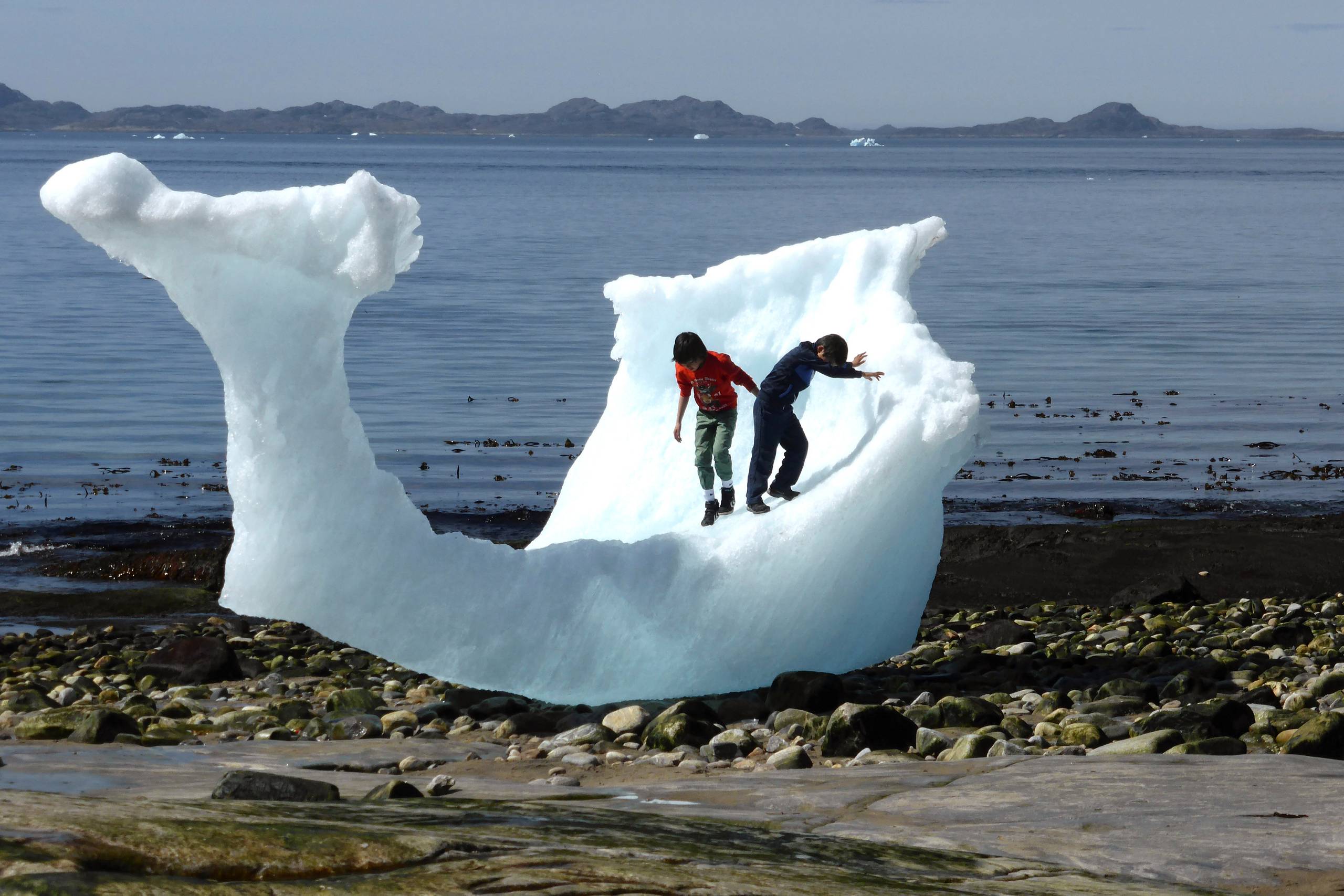 Børn leger på et stykke is i Nuuk. Foto: Ritzau Scanpix