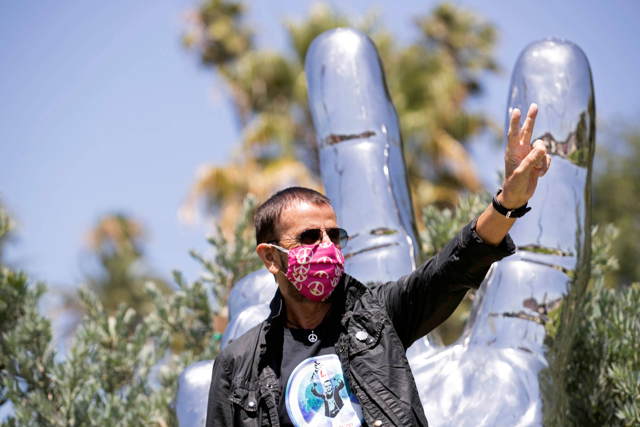     Musician Ringo Starr wears a face mask as he poses in front of his sculpture to celebrate his 80th birthday during the outbreak of the coronavirus disease (COVID-19), in Beverly Hills, California, U.S., July 7, 2020. Foto: Mario Anzuoni/Reuters