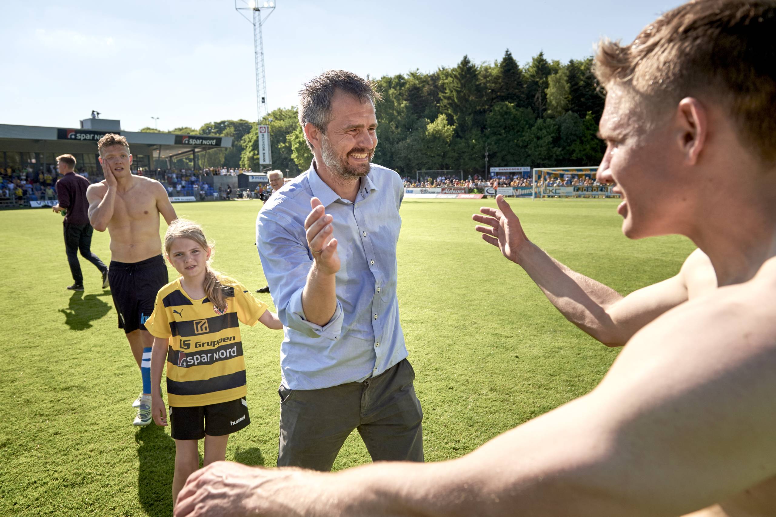 Sportschef Jens Hammer Sørensen - her i lyseblå skjorte - har haft masser at fejre i løbet af de seneste seks år i Hobro IK. Her er det oprykningen til Superligaen i 2017, som han håber på at gentage trods en sværere udsigt med en mindre Superliga fra næste sæson. Foto: Claus Bonnerup