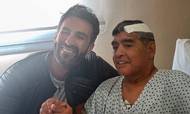 Diego Maradona sammen med sin læge Leopoldo Luque efter sin operation i hjernen i begyndelsen af november. Foto: Diego Maradona press office/AFP/TT