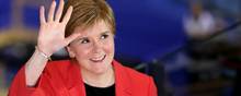 En smilende førsteminister, Nicola Sturgeon, i Glasgow, der kan glæde sig over, at mandater på vippen er blevet snuppet fra De Konservative og Labour, viser optællingen efter torsdagens parlamentsvalg i Skotland. Men hun advarer mod at tro, at flertallet er hjemme for hendes parti SNP. Foto: Russell Cheyne/Reuters