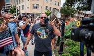 Alex Jones taler i megafon på gaden i Texas under en protest imod covid-19-restriktioner i juni 2020. Konspirationsteoretikeren er en nær støtte af Donald Trump. Foto: Sergio Flores/Reuters