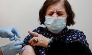 En israelsk kvinde modtog mandag sit fjerde vaccinestik i hovedstaden Tel Aviv. Foto: Amir Cohen/Reuters