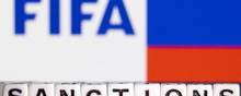 Plastic letters arranged to read "Sanctions" are placed in front the FIFA logo and Russian flag colors in this illustration taken February 28, 2022. REUTERS/Dado Ruvic/Illustration