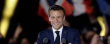 Den franske præsident, Emmanuel Macron, smiler og holder sig for hjertet, da han ankommer for at holde en tale efter at være blevet genvalgt som præsident. Foto: Benoit Tessier/Reuters