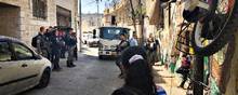 Israelske betjente i Silwan – et palæstinensiske kvarter i Østjerusalem – er dukket op med en kranvogn for at fjerne et palæstinensisk flag i lysledningerne over vejen. Silwan er et af de områder, hvor jødiske bosættere er begyndt at rykke ind. Det fører jævnligt til konfrontationer.  Foto: Heidi Plougsgaard