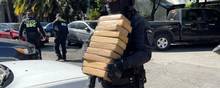 En politibetjent beslaglægger en del af den kokain, som blev fundet i hemmelige rum på en trailer i udkanten af Mexico City. Foto: Mexico City Ssc/Reuters