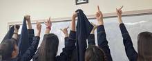 Et billede fra de sociale medier viser skolerpiger i Iran give fingeren til et billede af landets øverste leder og hans forgænger. Foto: Twitter