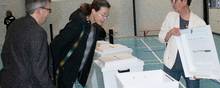 Den første vælger i Mørke, Kristine Godt, tjekker, at urnerne er tomme, inden hun går ind i boksen og afgiver sin stemme. Foto: Kim Frost