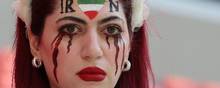 En iraner har under VM-kampen mellem Wales og Iran malet sorte tårer på sit ansigt for at vise støtte til anti-regimeprotesterne, der nu fortsætter på tredje måned i Iran. Foto: Giuseppe Cacace/AFP