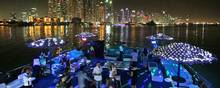 Dubai er blevet Golfens festby nummer et. Her danser festende gæster på en båd med Dubais skyline i baggrunden. Foto: Kamran Jebreili/AP