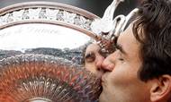 Switzerland's Roger Federer kisses the trophy after defeating Sweden's Robin Soderling during their men's singles final match of the French Open tennis tournament at the Roland Garros stadium in Paris, Sunday June 7, 2009. The victory gives Federer 14 Grand Slams, tying his career wins to American Pete Sampras. (AP Photo/Bernat Armangue)