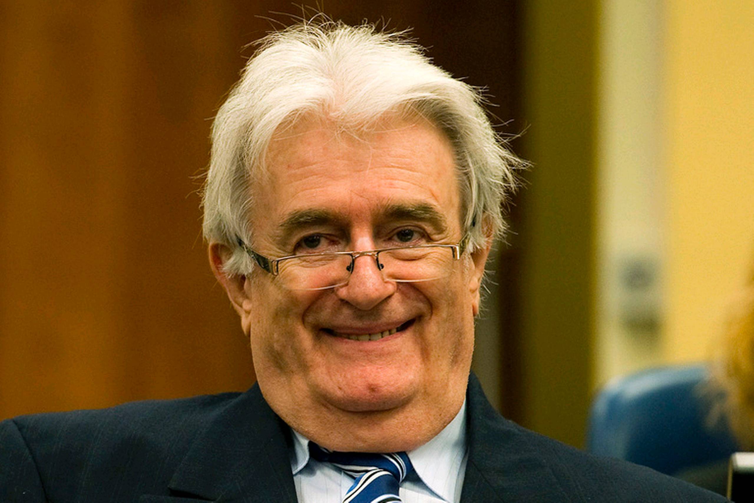 Karadzic, som var iført et sort jakkesæt, en blå skjorte og stribet blåt slips, smilede fra tid til anden under sin forklaring.