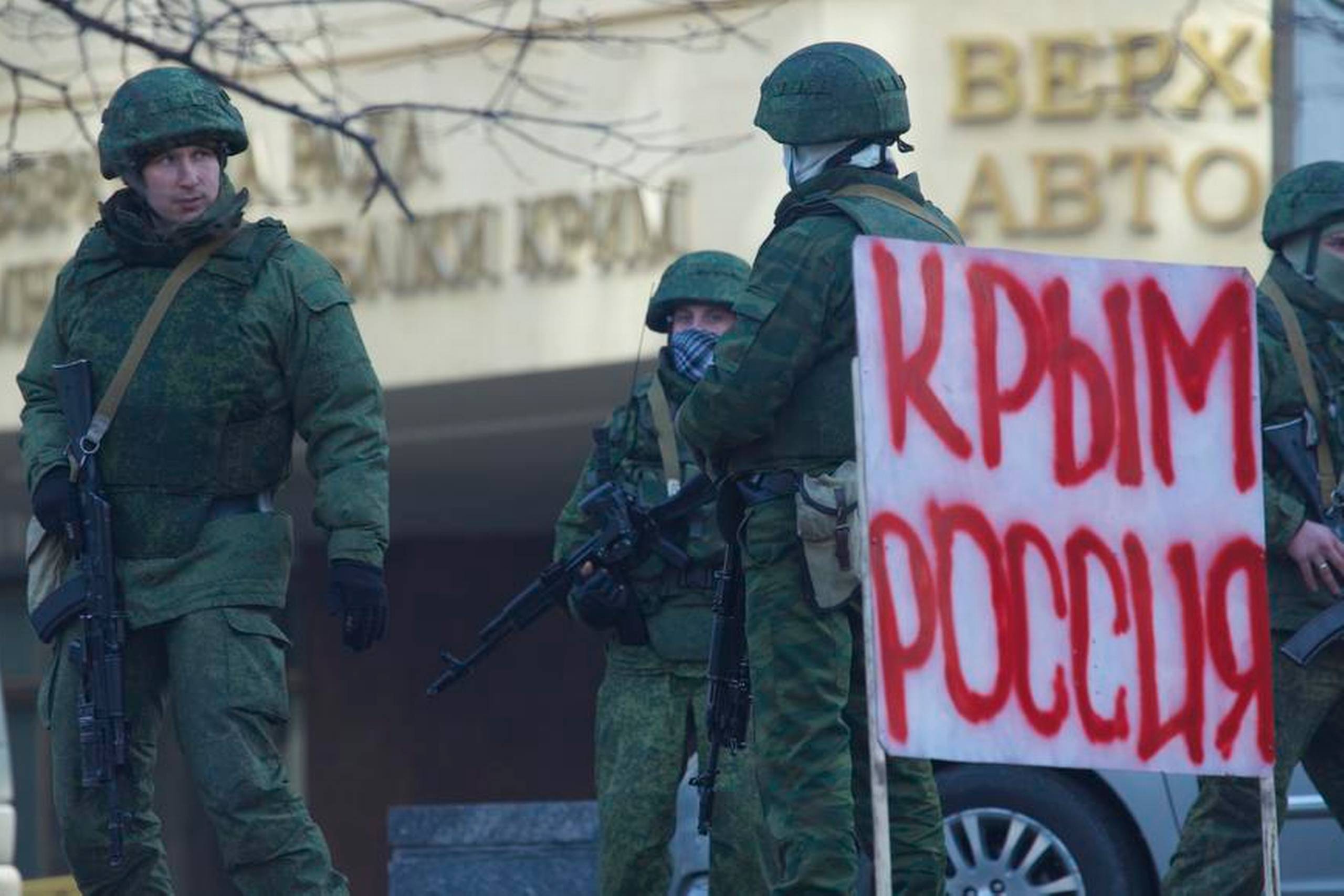 De uidentificerede tropper ved Krims parlament lørdag i Simferopol. Et efterladt banner fra en demonstration bærer teksten ”Krim – Rusland”. Foto: Ivan Sekretarev/AP