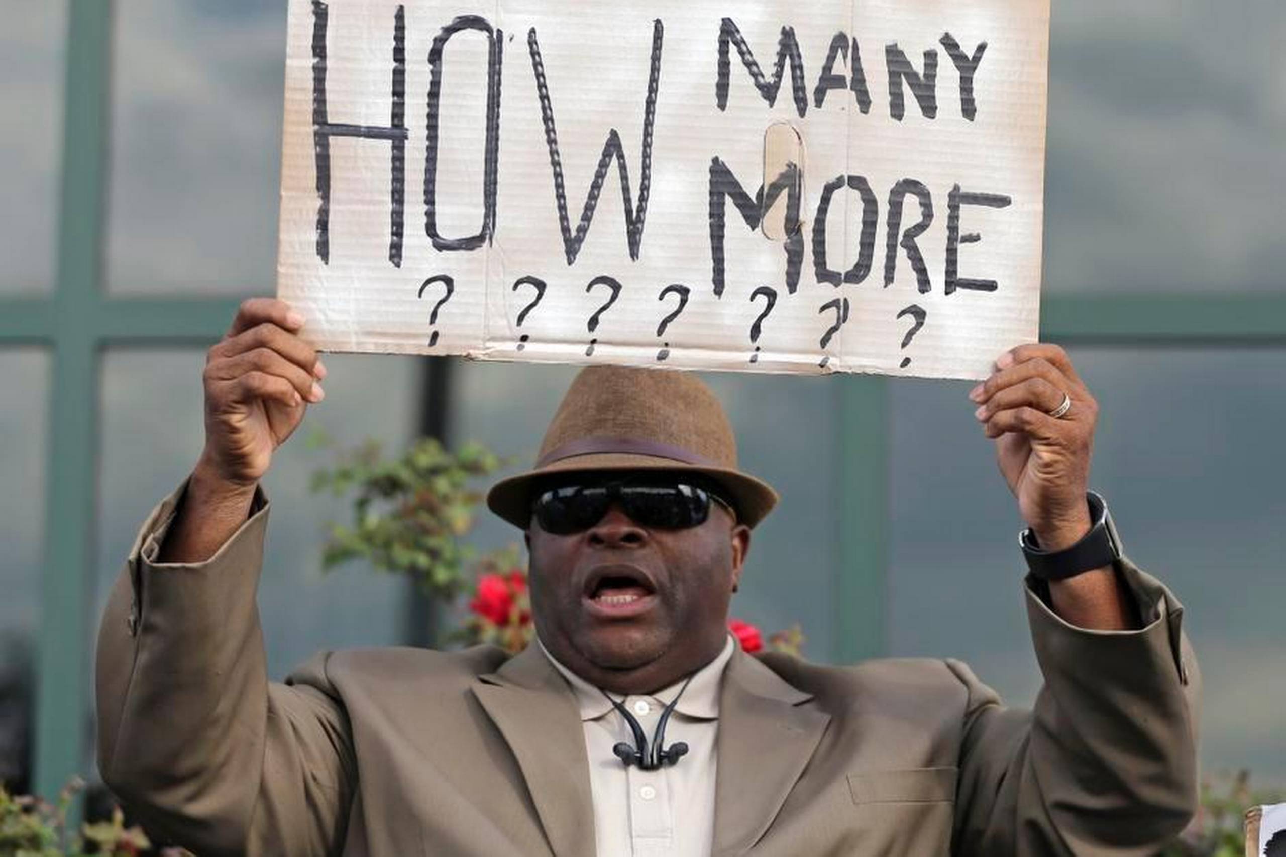 Pastor Arthur Prioleau protesterer ved rådhuset i North Charleston, South Carolina, over mordet på Walter Scott. ”Hvor mange flere?” lyder spørgsmålet på skiltet. Betjenten Michael Thomas Slager er blevet sigtet for mordet. Foto: Chuck Burton/AP
