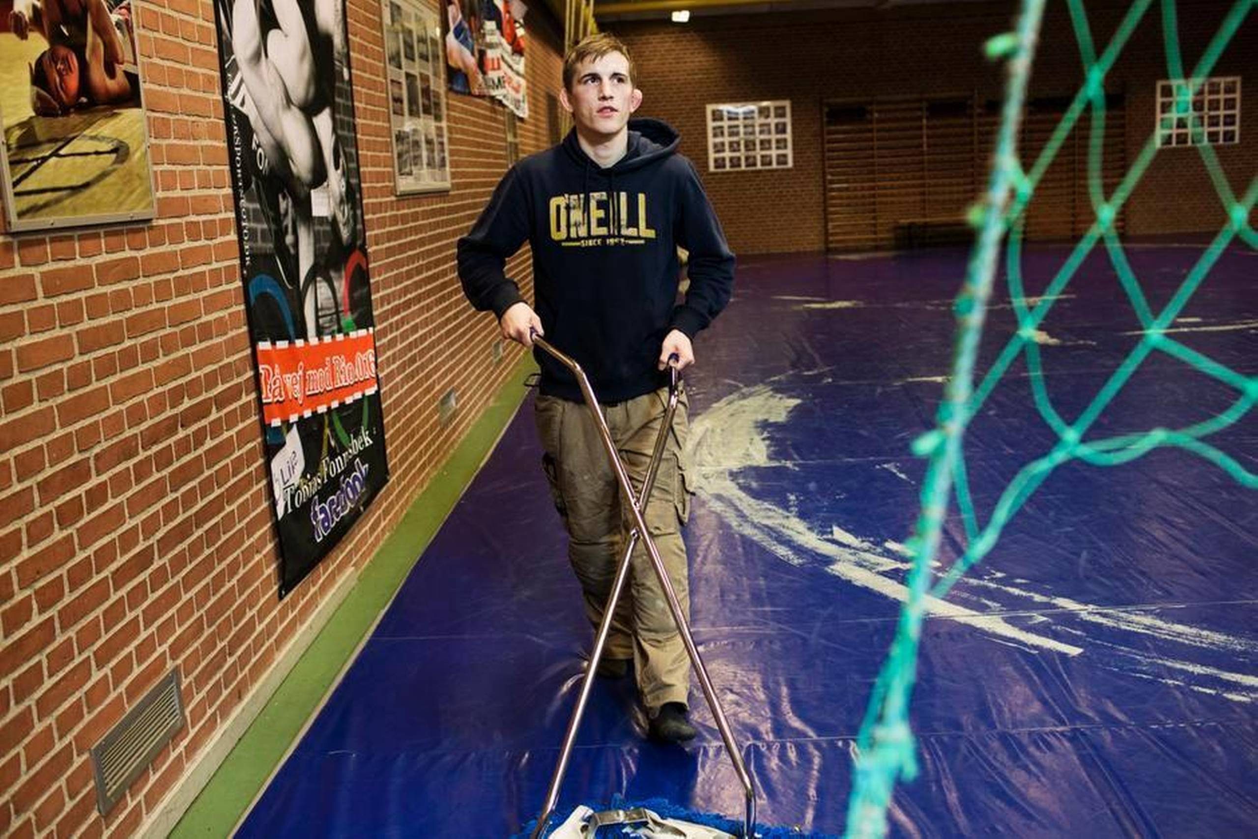 Efter et stykke tid som arbejdsløs kom Tobias Fonnesbek i praktik i Brydeklubben Thrott i Åbyhøj, hvor han selv er medlem. Så kunne han selv moppe måtten efter sin træning. Foto: Gregers Tycho