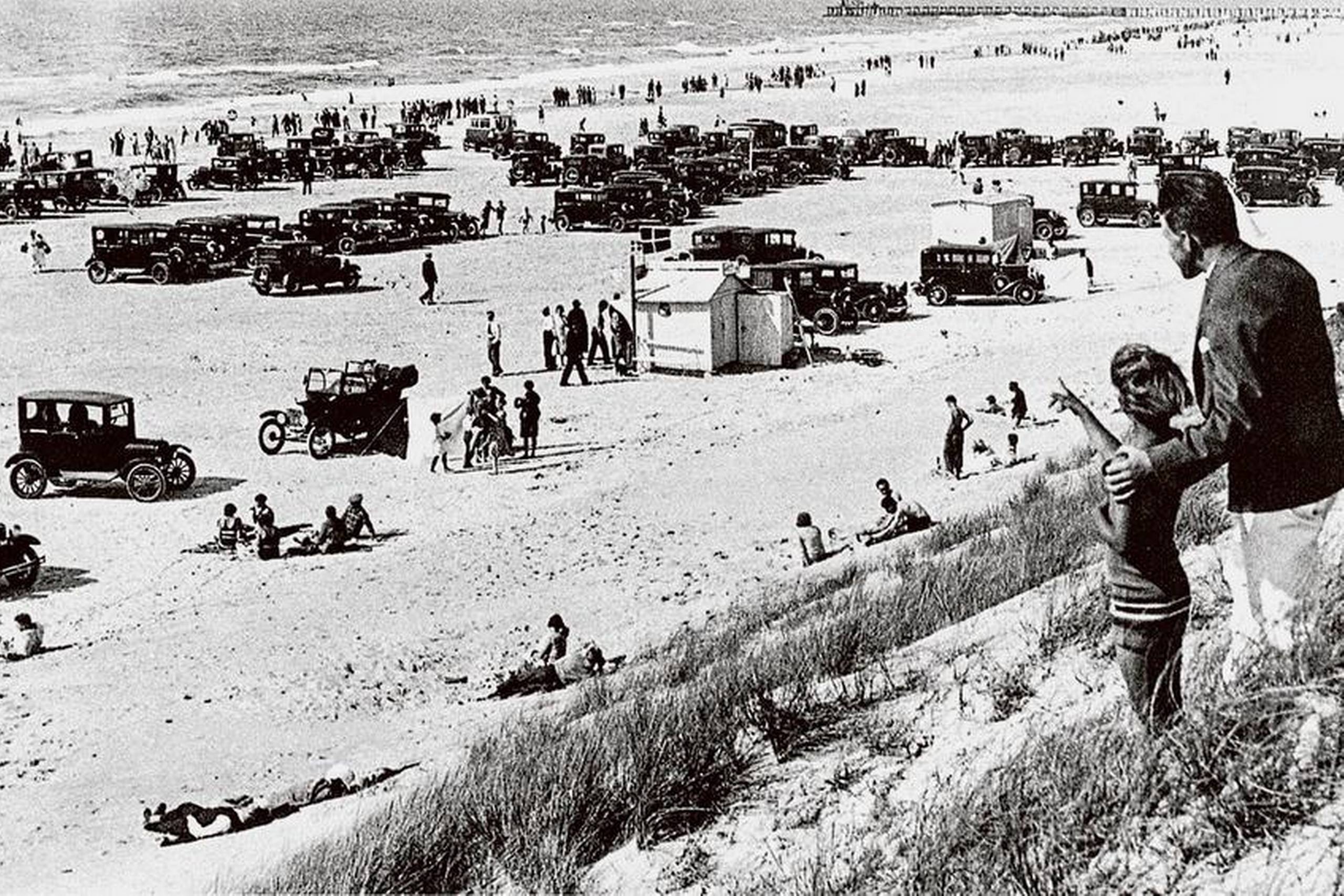 Selv om personbiler i 1930’erne var forbeholdt over- og middelklasse, viser fotografiet fra Løkken Strand klart, hvordan fritidslivet allerede i mellemkrigstiden antog mange af de former, som for alvor slog igennem for flertallet af danskere fra 1960’erne. Den oprindelige billedtekst udtrykte bekymring over de alt for mange biler på stranden. Det skulle blive meget værre. Arkivfoto: Scanpix