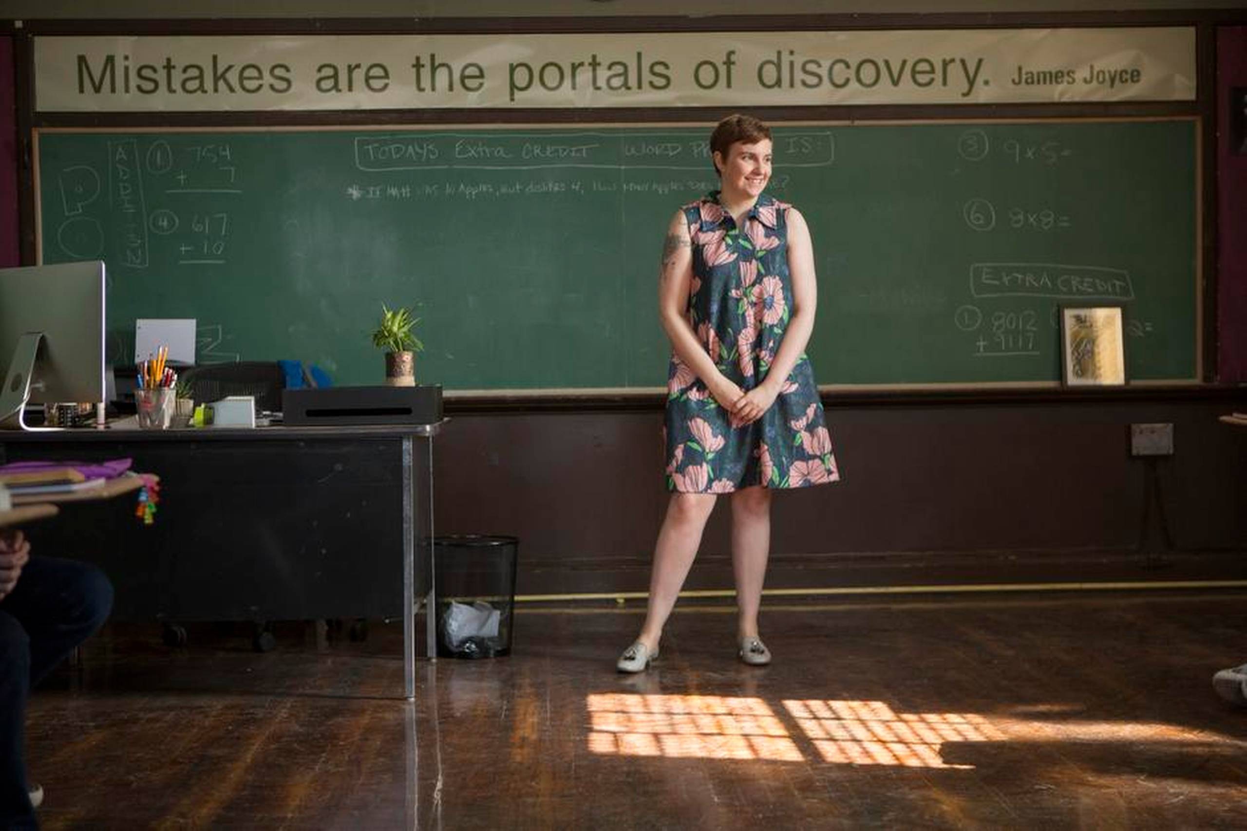 Lena Dunham alias Hannah i lidt for kort, storblomstret kjole. På væggen bag hende står James Joyce-citatet: ”Mistakes are the portals to discovery”, meget betegnende for seriens karakterer, der ikke altid tager de rigtige valg. Foto: HBO