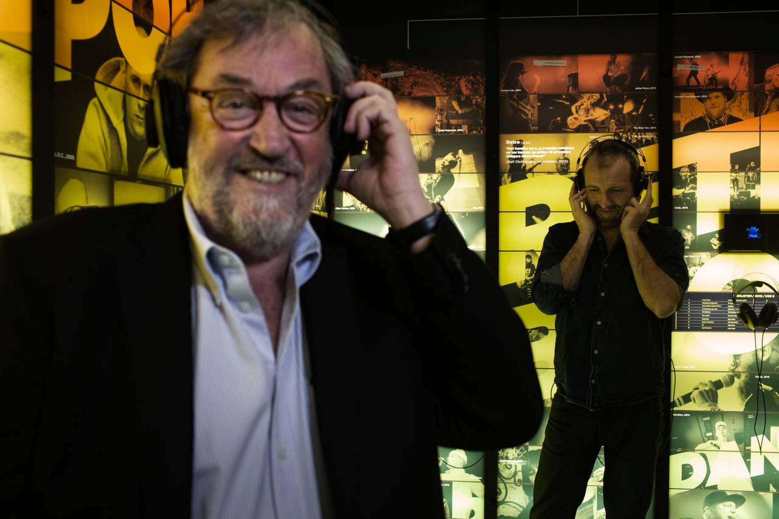 Museumsdirektør Frank Birkebæk (tv.) og Jacob Westergaard Madsen, som er daglig leder af Ragnarock, har med hovedtelefoner koblet sig på den store musikvæg, der præsenterer masser af dansk musik. Foto: Mathias Svold
