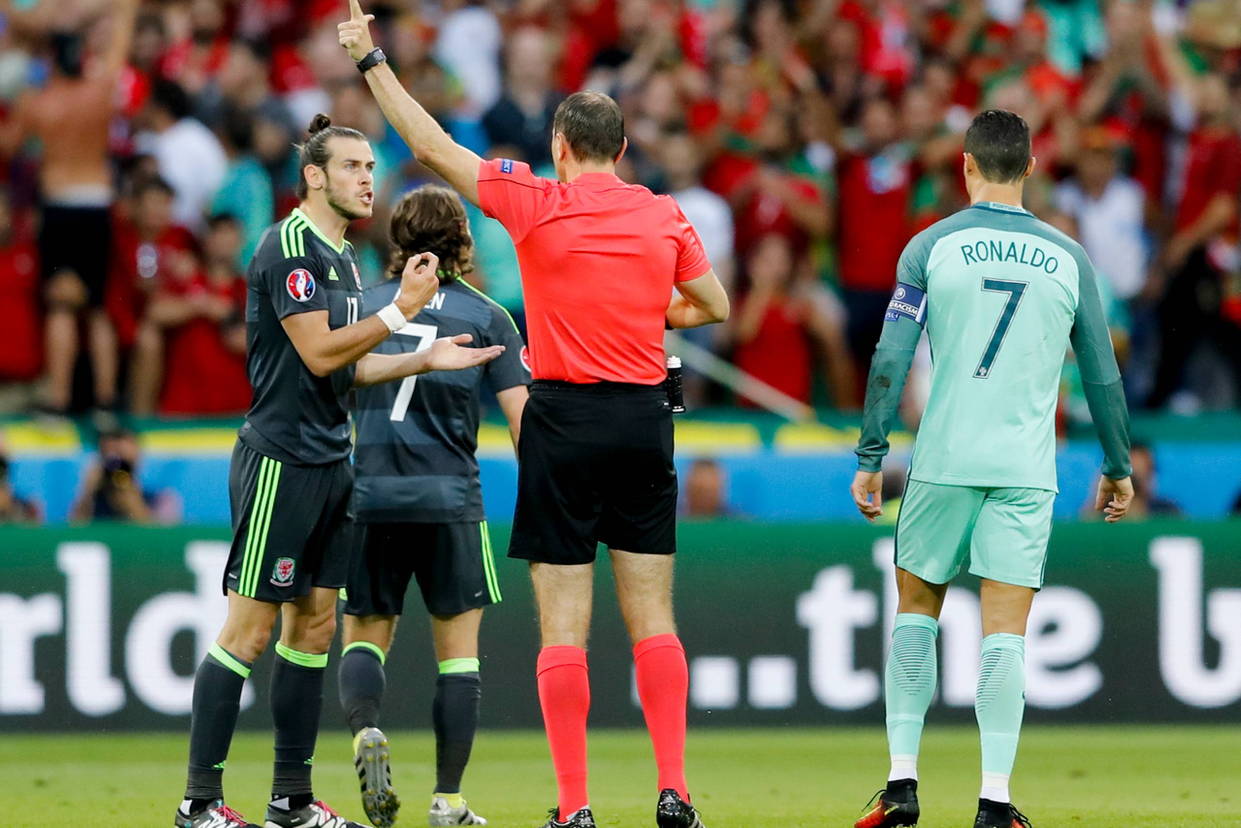 Wales-spilleren Gareth Bale taler med dommer Jonas Eriksson, mens Cristiano Ronaldo fra Portugal står til højre. Foto: Frank Augstein/AP