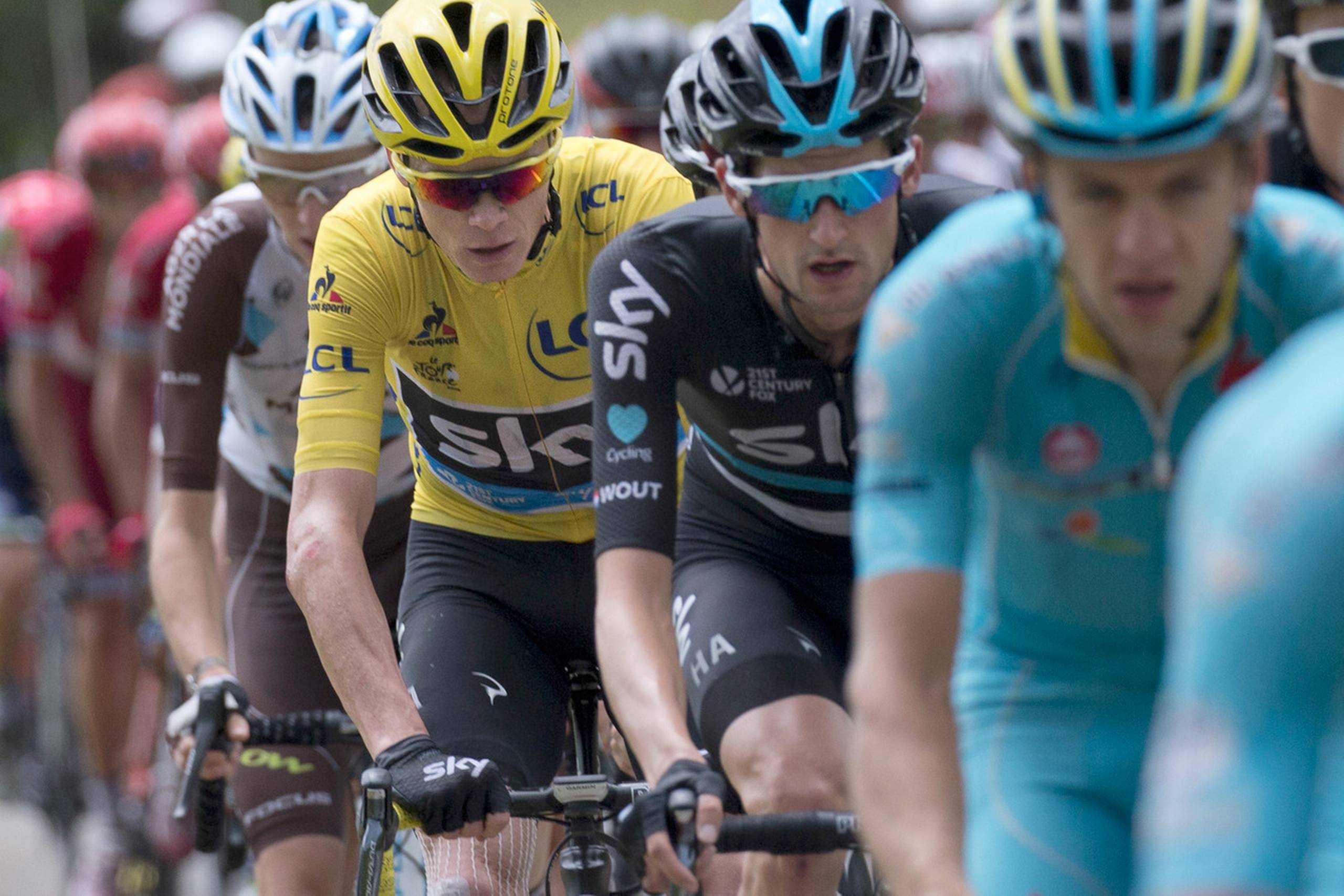 Tour-karavanen med Chris Froome i gult når i dag frem til Paris og løbets afslutning. Der er tradition for, at mange ryttere mødes med deres familier, når etapen er slut, men mange bliver, ifølge Lars Bak, væk pga. terrorfrygt. Foto: Peter Dejong/AP