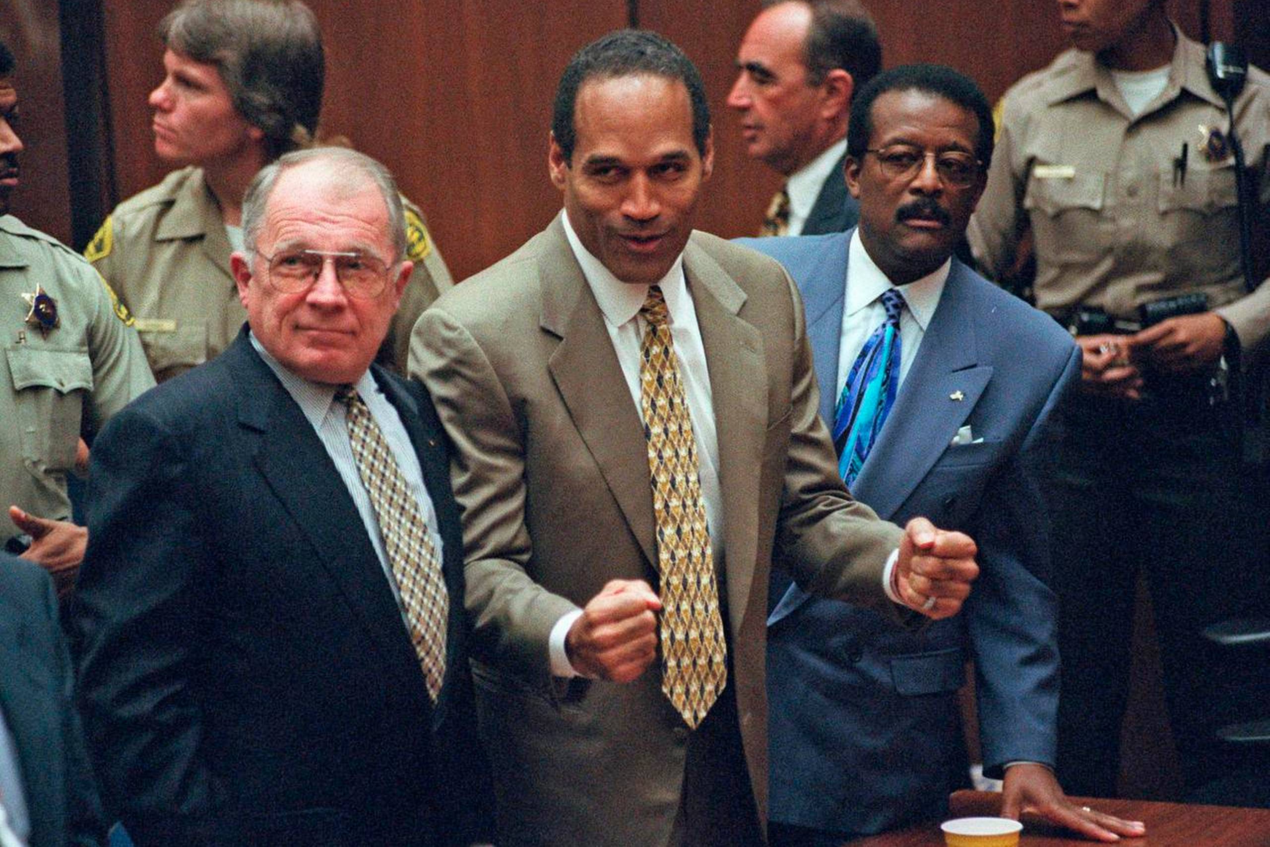 Afgørelsen er faldet, og O.J. Simpson frikendes. I baggrunden ses advokat Robert Shapiro. Lige bag ved sportsstjernen står Johnnie Cochran, der førte sagen og forrest F. Lee Bailey, som leverede det vigtige krydsforhør af af politimand Mark Fuhrman. Foto: AP