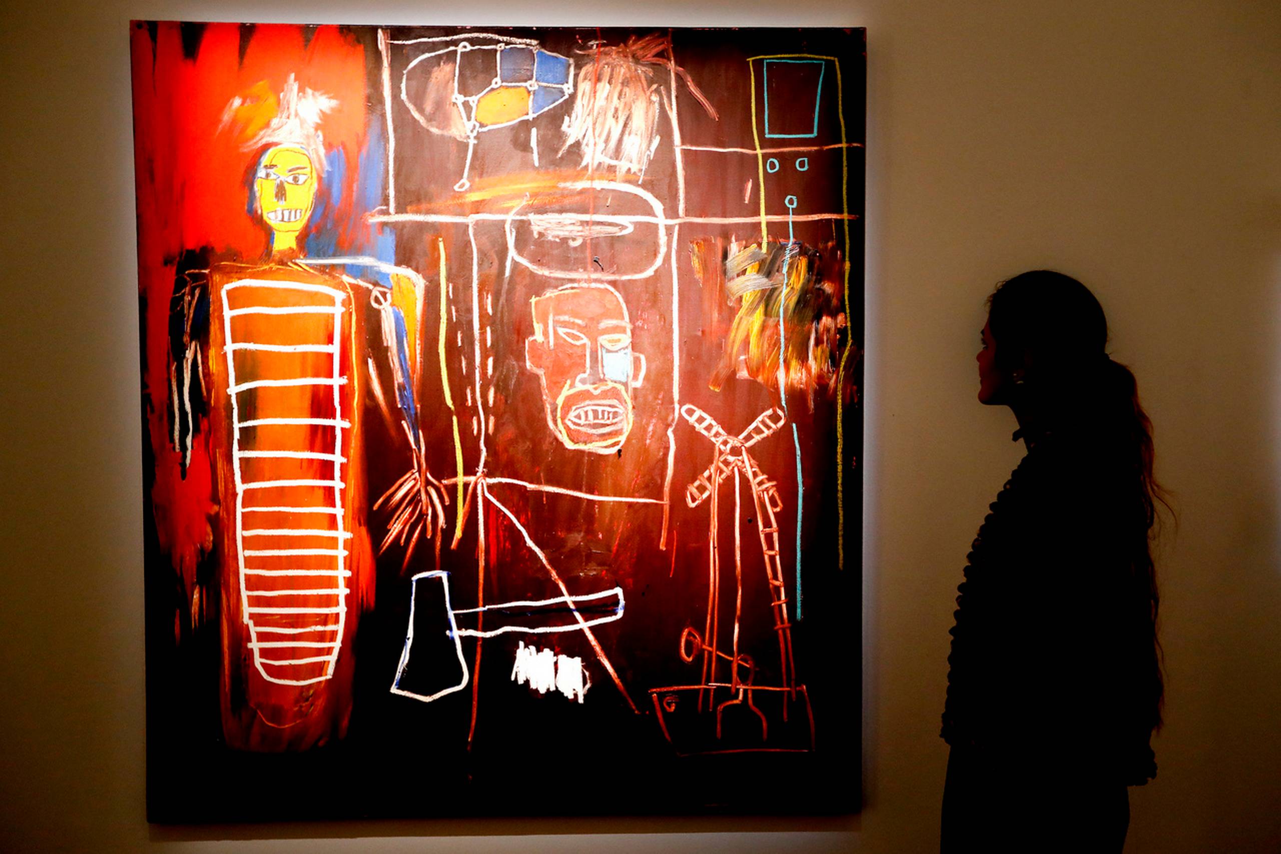 En kvinde studerer Jean-Michel Basquiats værk "Air Power' fra 1984. Foto: Kirsty Wigglesworth/AP