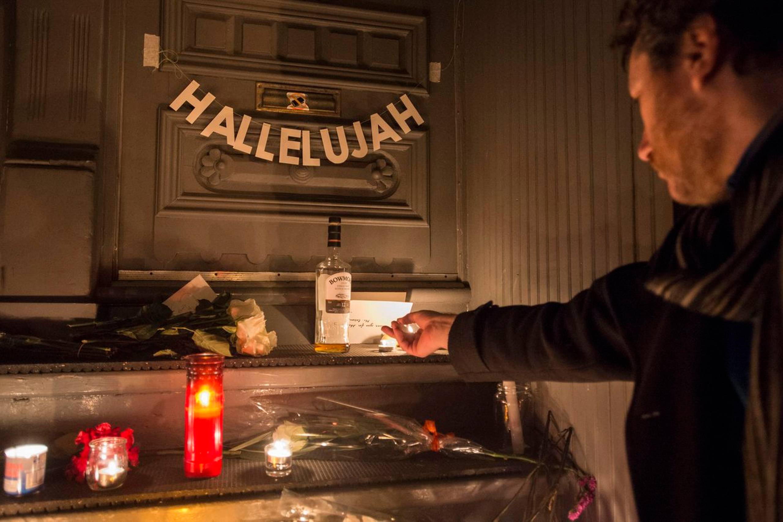 En mand tænder lys ved Leonard Cohens hjem i Montreal. Annonceringen af Leonard Cohens død kom først fredag - dagen efter begravelsen. Han blev 82 år. Foto: Paul Chiasson/AP