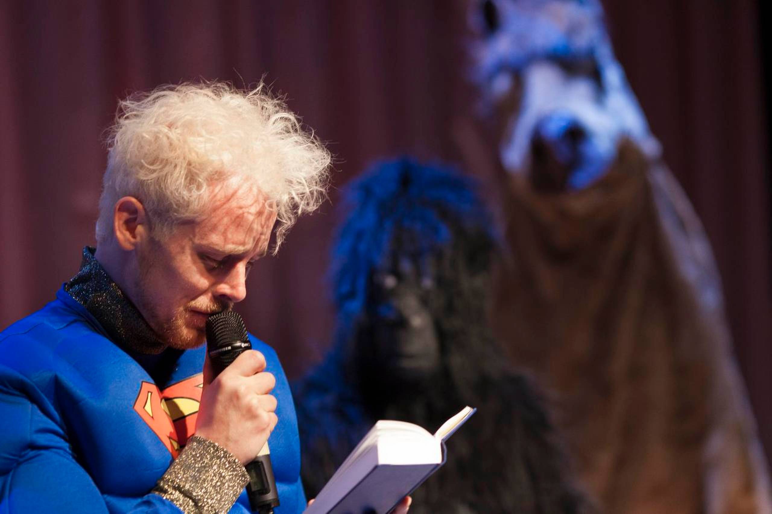 Tobias Shaw forklædt som Superman synger højt fra Højskolesangbogen på Teater Momentum i Odense. Foto: Henrik Grimbäck