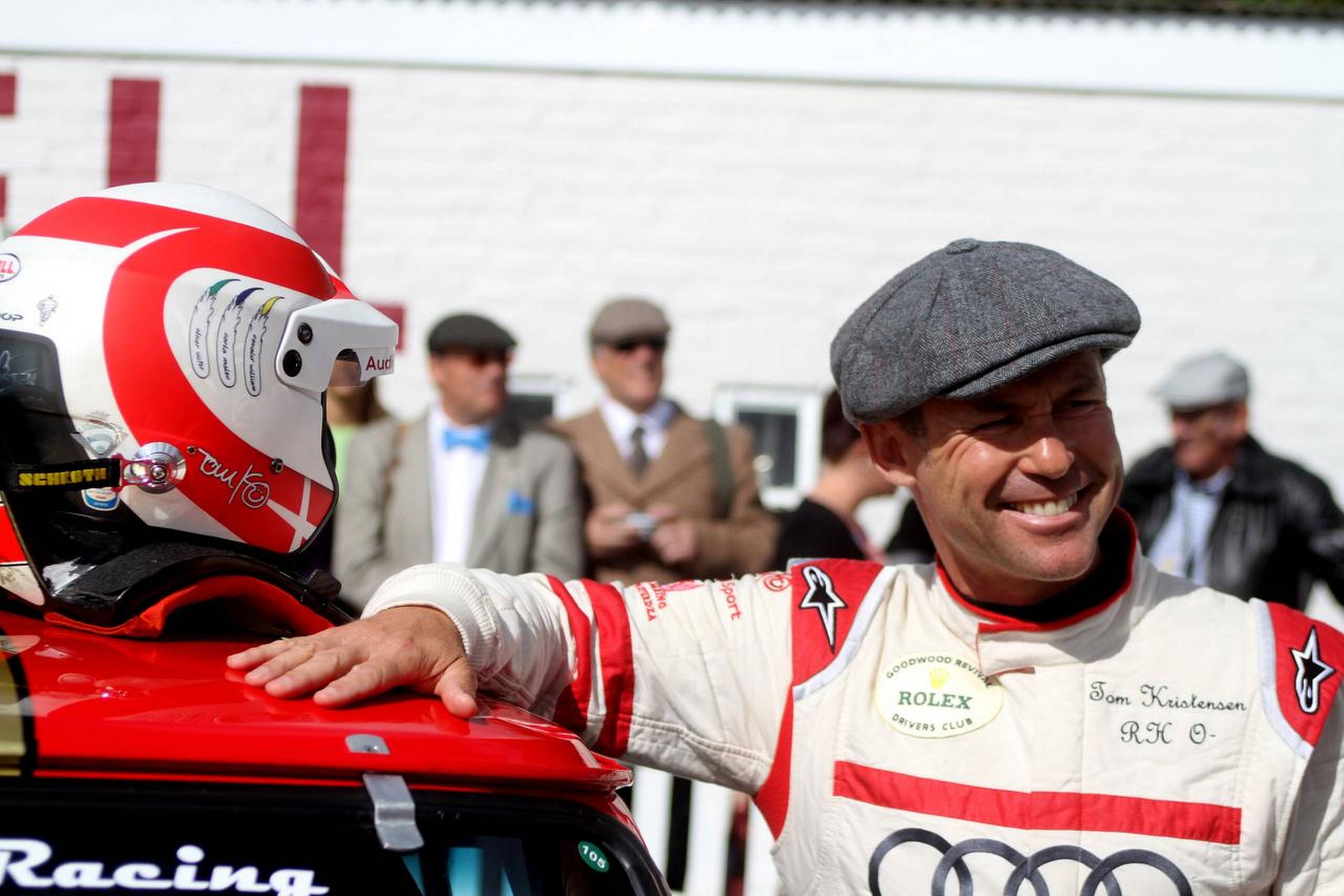 Præcist sådan kender Goodwood-fans Tom Kristensen. Det der drengede smil, Audi-dragten og Karl Smart-sixpence. Foto: Flemming Haslund