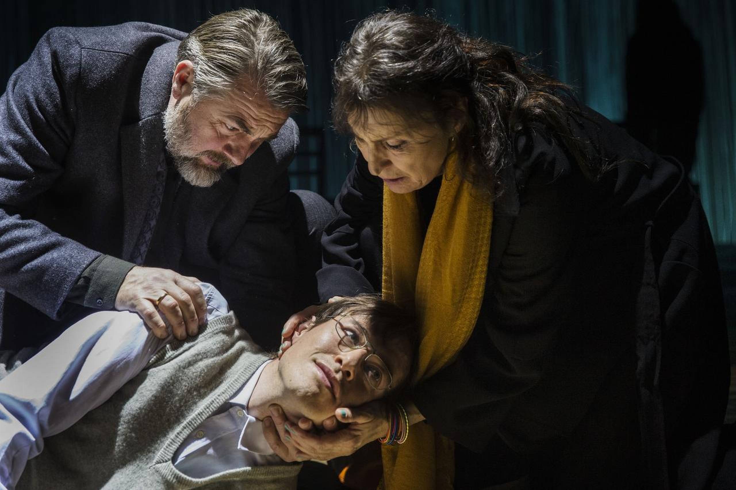 Sønnen (en liggende Peter Christoffersen) er på evig jagt efter tryghed – her sammen med moderen (Karen-Lise Mynster) og faderen (Jens Jørn Spottag). Foto: Det Kgl. Teater