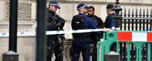 Bevæbnet politi taler med en person efter en episode, hvor en mand blev anholdt ved det britiske parlament. Foto: Dominic Lipinski/AP
