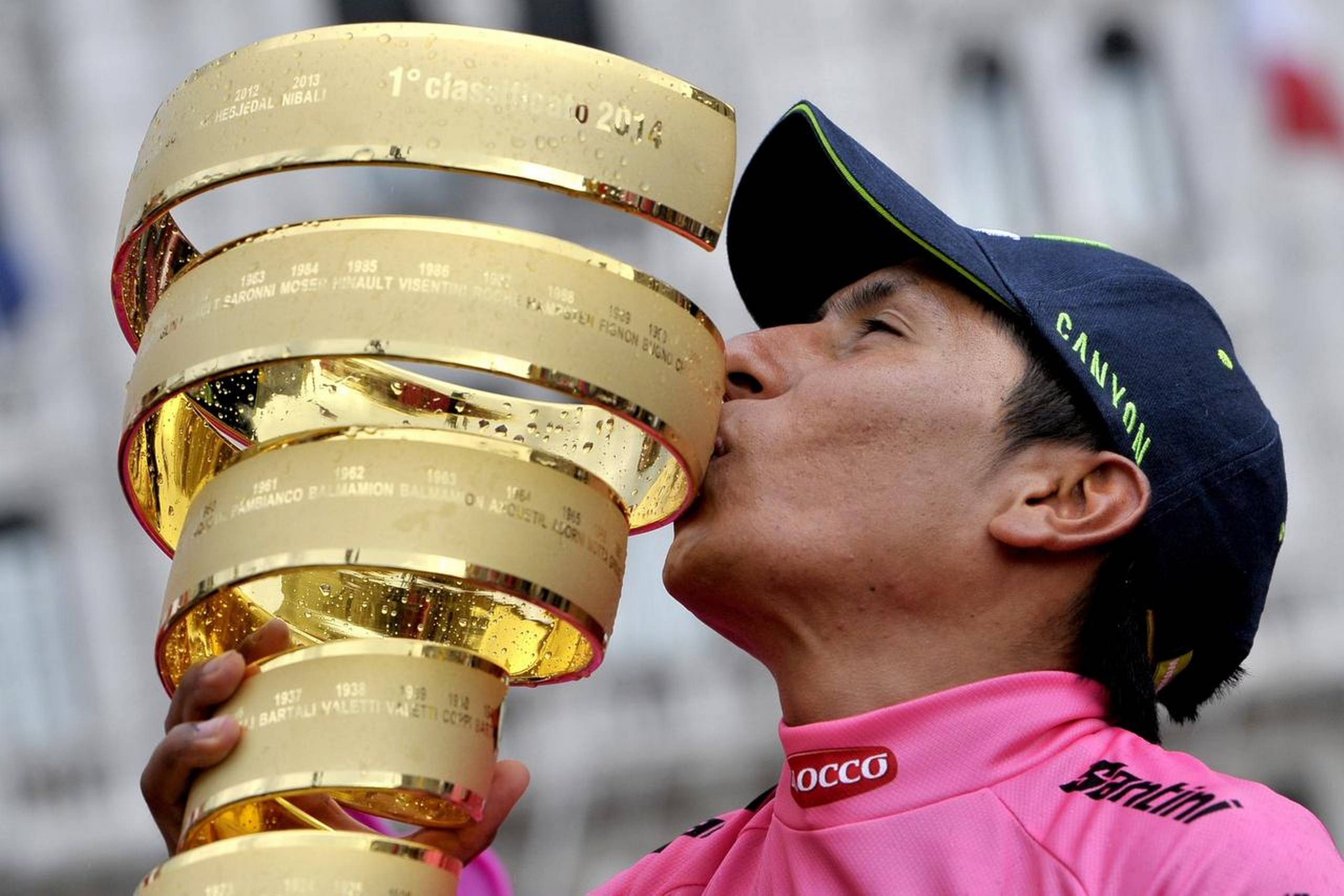 Nairo Quintana kysser pokalen efter sin Giro d´Italia-sejr i 2014. I år vil han forsøge at vinde både Giro d´Italia og Tour de France. Og netop han har en chance for at gøre det, der af mange betragtes som umuligt i moderne cykling. Det mener en tidligere double-vinder, ireren Stephen Roche. Foto: Marco Alpozzi