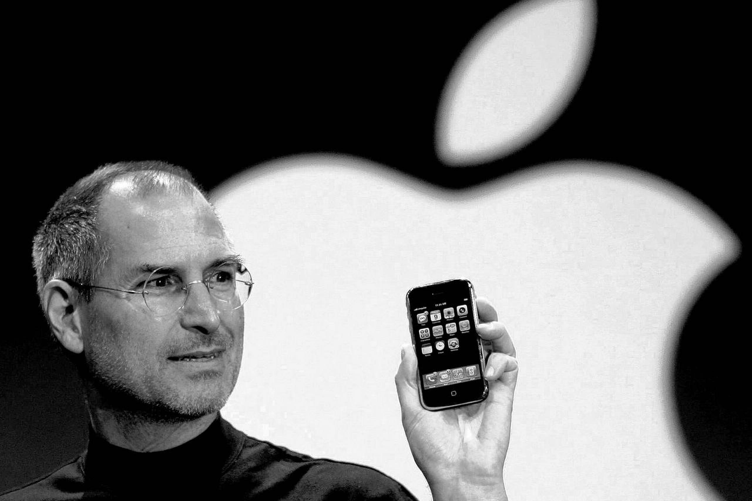 En stolt far med sin nyfødte. Den nu afdøde Apple-chef Steve Jobs præsenterer iPhonen ved MacWorld Conference i San Francisco d. 9. januar 2007. Omtrent et halvt år senere, d. 29. juni 2007, kom den ud i butikkerne og revolutionerede hele brancher og menneskelige relationer. Foto: AP