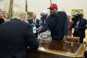 Kanye West viser Donald Trump et foto på sin telefon under mødet i Det Hvide hus. Foto: Evan Vucci/AP